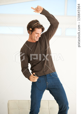 Dance, headphones and man with phone in home to celebrate freedom, enjoy happy subscription and hearing digital audio. Excited guy listening to music, radio and sound on mobile smartphone with energy Dance, headphones and man with phone in home to celebrate freedom, enjoy happy subscription and hearing digital audio. Excited guy listening to music, radio and sound on mobile smartphone with energy 138645964