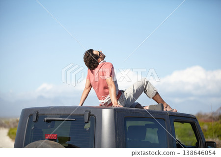 Travel, man and sitting on van roof for scenery, nature and fresh air on adventure or vacation in South Africa. Person, tourist or traveler on rooftop of car with sunglasses for view or road trip 138646054