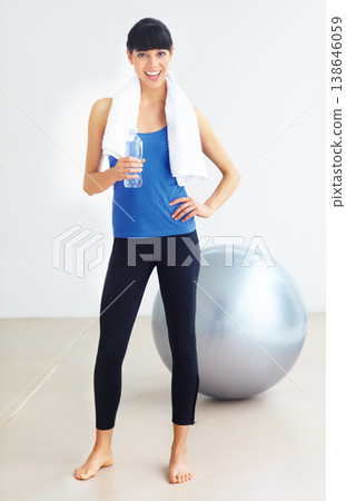 Portrait, fitness and woman with a water bottle, smile and exercise with hydration, towel and wellness. Healthy person, girl and athlete with liquid, aqua and workout with training, thirsty and ball 138646059