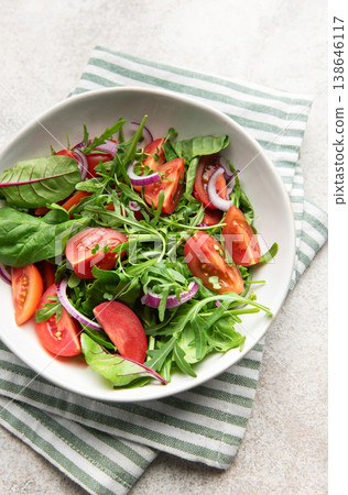 Bowl holding healthy green salad on striped napkin Bowl holding healthy green salad on striped napkin 138646117