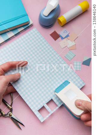 Hand using punch tool creating decorative craft stamps Hand using punch tool creating decorative craft stamps 138646140