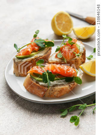 Smoked salmon bruschetta with avocado, cream cheese, and microgreens Smoked salmon bruschetta with avocado, cream cheese, and microgreens 138646148