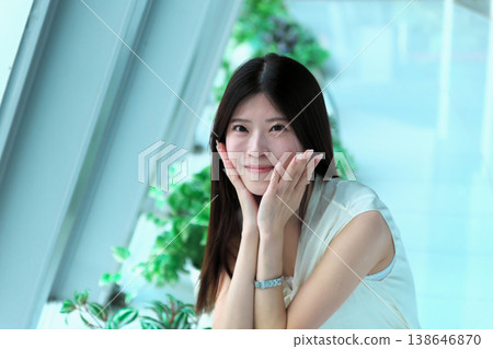 一位身穿無袖連身裙的年輕女子蹲下身子,轉過身來。 一位身穿無袖連身裙的年輕女子蹲下身子,轉過身來。 138646870