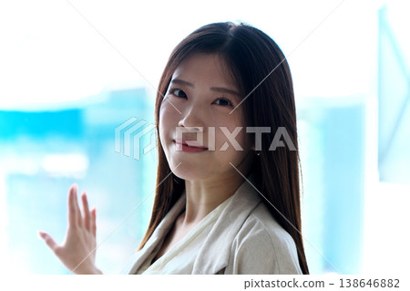 A young woman in a sleeveless dress crouches down and turns around. 138646882