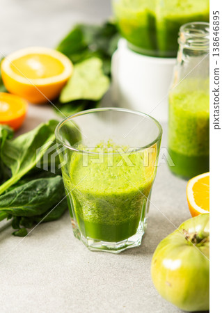 Fresh juice is made using spinach, chard, and broccoli along with oranges and tangerines. A glass of green juice sits by fresh ingredients on a clean kitchen counter Fresh juice is made using spinach, chard, and broccoli along with oranges and tangerines. A glass of green juice sits by fresh ingredients on a clean kitchen counter 138646895