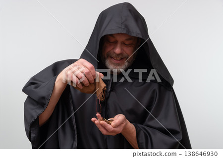 Elderly monk smiling while holding a donation pouch on white background. 138646930