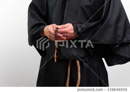 Close up of monk hands with rosary in black robe, isolated. 138646939