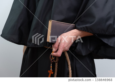 Close up of monk hands holding book and rosary isolated. Close up of monk hands holding book and rosary isolated. 138646968