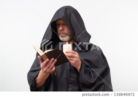Bearded monk in hood focused reading text, isolated. 138646972