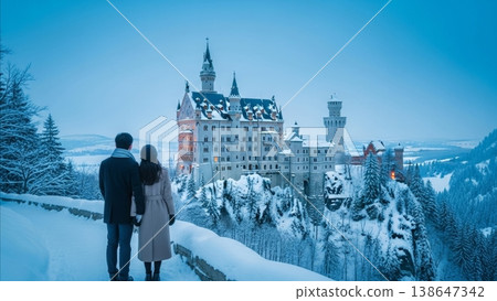 Travel - Asian Couple Standing in Snow Viewing Illuminated Neuschwanstein Castle at Winter Dusk in Bavaria Germany 138647342