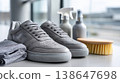 Faceless artisan cleaning premium leather sneakers, specialized tools and eco-friendly solutions display, Sustainable Shoe Care, bright modern studio interior shown. 138647698