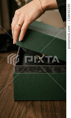 Close Up of Hands Lifting Lid of Premium Forest Green Box 138648190