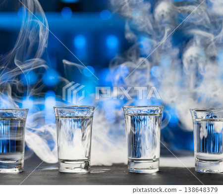 vodka shots with smoke on dark bar vodka shots with smoke on dark bar 138648379