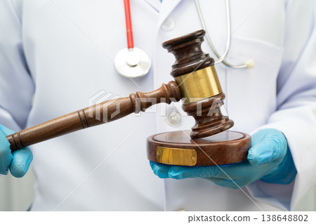 Asian doctor holding court hammer for and crime law justice, forensic medicine. 138648802