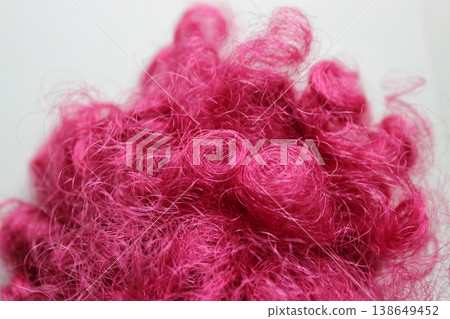 Balls of tangled pink fake hair on a white background Balls of tangled pink fake hair on a white background 138649452