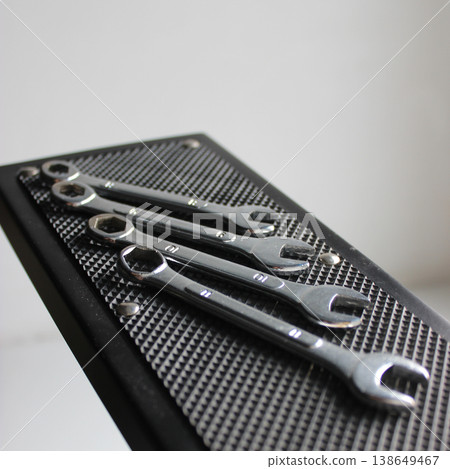 Square stock photo of numbered spanners on textured rubber surface of hanging shelf Square stock photo of numbered spanners on textured rubber surface of hanging shelf 138649467