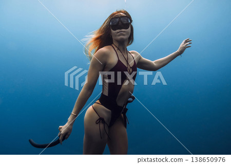 Portrait of woman freediver underwater in blue sea water Portrait of woman freediver underwater in blue sea water 138650976