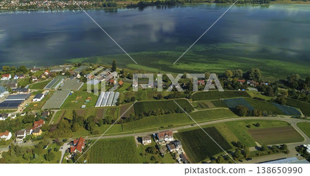 Aerial view of farmland and lake during daylight with fields and buildings in Germany Aerial view of farmland and lake during daylight with fields and buildings in Germany 138650990