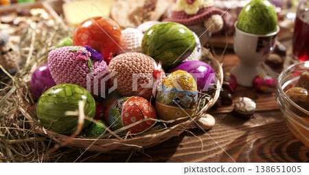 Colorful eggs in a basket on a wooden table during a festive spring celebration in a cozy indoor setting Colorful eggs in a basket on a wooden table during a festive spring celebration in a cozy indoor setting 138651005