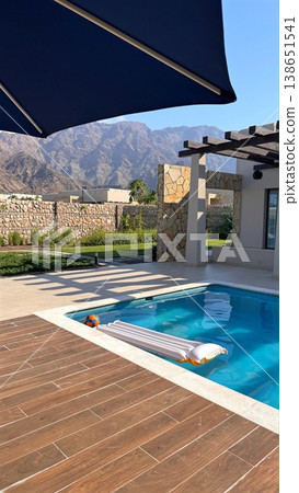 Peaceful Villa Patio With Shaded Seating Area. Idyllic Vacation Escape Offering Tranquil Poolside Terrace Surrounded By Majestic Mountains And Comfortable Lounging Options 138651541