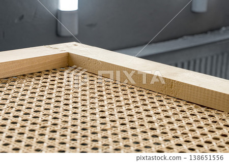 Wooden frames with stretched rattan in a painting booth ready for finishing and coating processes 138651556