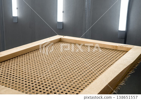 Wooden frames with stretched rattan in a spray booth for painting and finishing wooden furniture pieces 138651557