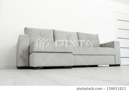 Grey sofa in a room with white wallpaper Grey sofa in a room with white wallpaper 138651821
