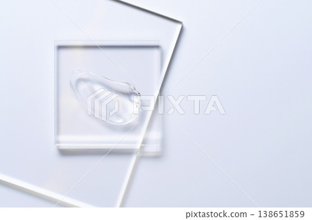 A sample of a transparent cosmetic skin care product on glass. Blue background A sample of a transparent cosmetic skin care product on glass. Blue background 138651859