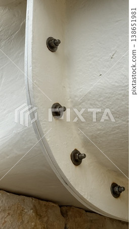 Metal bolts on white painted industrial surface with textured background and rust details Metal bolts on white painted industrial surface with textured background and rust details 138651981