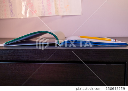 Open notebook with pencil on a desk in room Open notebook with pencil on a desk in room 138652259