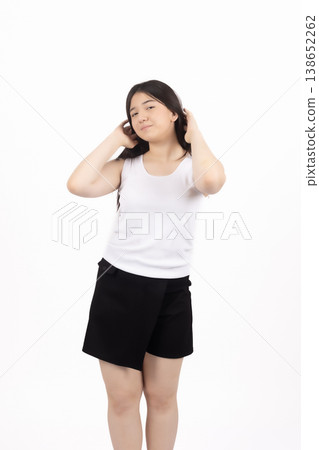 Woman hiding her face with hands in a studio setting Woman hiding her face with hands in a studio setting 138652262