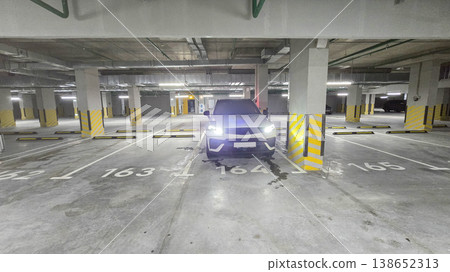 Blue sedan navigates an empty parking garage Blue sedan navigates an empty parking garage 138652313