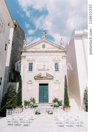 Sunny Wedding Setting. Sundrenched Stone Church With Floral Accents And Elegant Aisle Arrangement 138652333
