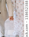Closeup Of Hands During Stroll. Holding Hands While Walking In Floral Dress And Suit 138652388