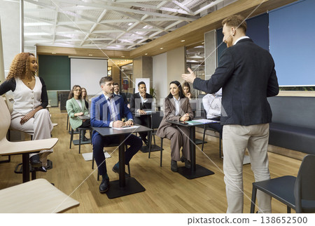 Corporate team engaging with speaker at business training seminar in office 138652500