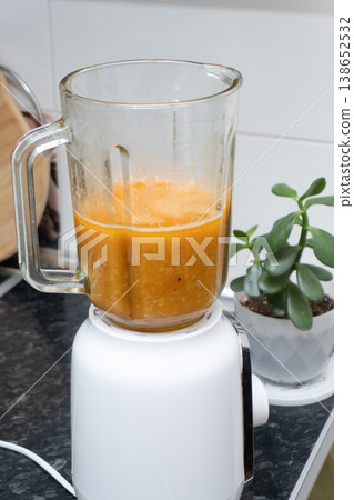 Pureed pumpkin soup in a glass blender on a kitchen counter Pureed pumpkin soup in a glass blender on a kitchen counter 138652532