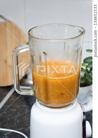 Glass blender with red lentil cream soup on a kitchen counter Glass blender with red lentil cream soup on a kitchen counter 138652533