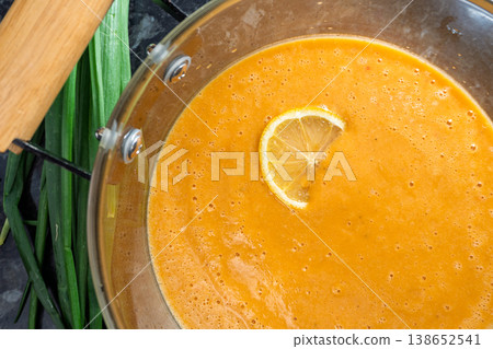 Creamy red lentil soup garnished with lemon slice in a glass pot Creamy red lentil soup garnished with lemon slice in a glass pot 138652541