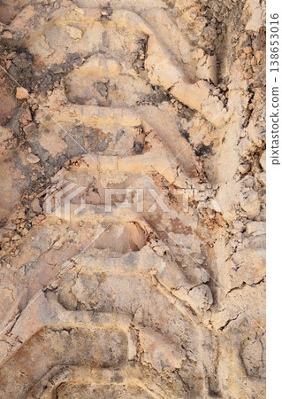 Detailed texture of tire tracks on wet sand or soil 138653016