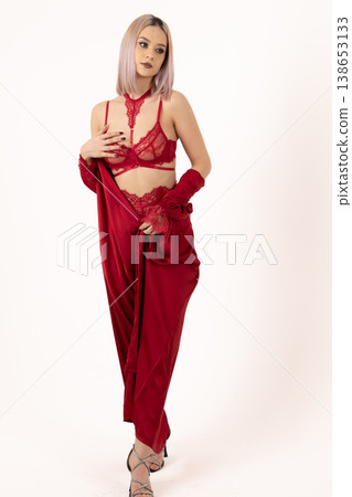 Beautiful woman in red silk ensemble posing against white background Beautiful woman in red silk ensemble posing against white background 138653133