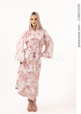 Fashionable blonde woman in floral robe standing in studio Fashionable blonde woman in floral robe standing in studio 138653165
