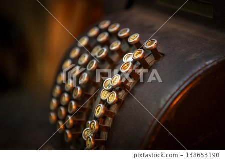 Classic black cash register elegantly displayed on a rustic wooden table in a cozy caf setting. 138653190