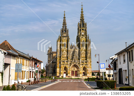 A view of the flamboyant gothic facade and spires of the Basilica of Notre-Dame de l'Epine at the end of a street in Marne, France 138653205