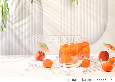 Iced peach tea or cocktail with mint and apricots, refreshing summer drink recipe. Two glasses with peach fruit lemonade on a light table, detox diet and weight loss concept, restaurant menu, Iced peach tea or cocktail with mint and apricots, refreshing summer drink recipe. Two glasses with peach fruit lemonade on a light table, detox diet and weight loss concept, restaurant menu, 138653207