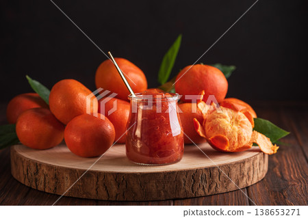 Fresh tangerines with green leaves arranged on wooden slab Fresh tangerines with green leaves arranged on wooden slab 138653271