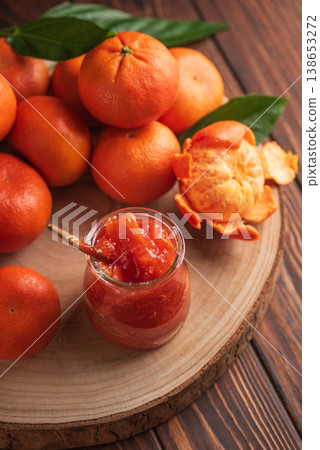 Fresh tangerines with green leaves arranged on wooden slab Fresh tangerines with green leaves arranged on wooden slab 138653272