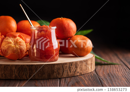 Fresh tangerines with green leaves arranged on wooden slab Fresh tangerines with green leaves arranged on wooden slab 138653273
