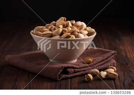 Pistachios in Rustic Ceramic Bowl on Dark Wooden Background Pistachios in Rustic Ceramic Bowl on Dark Wooden Background 138653286