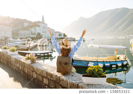 Tourist woman admiring view of colorful view of city. Back view. Europe travel. Lifestyle, nature. 138653321