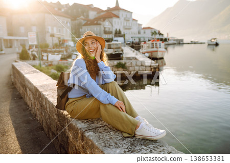Young female tourist enjoys view of the city. Europe travel. Vacation, tourism, nature, active life. 138653381